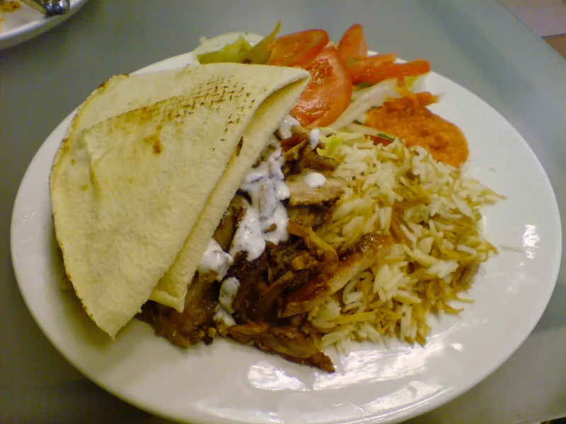 شاورما بصوص الثومية مع رز بالشعرية وعيش شامي وسلطة في طبق